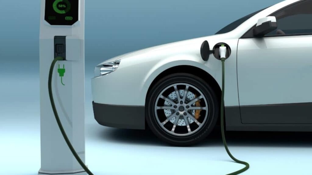 Technician inspecting an electric vehicle battery using a diagnostic tool.